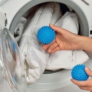 Een donsjack wassen in een wasmachine met ballen