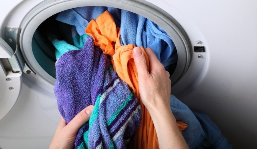 For at begynde at tørre i vaskemaskine-tørretumbleren skal noget af vasketøjet trækkes ud.