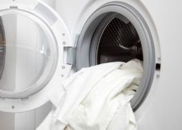Tvättar en vit skjorta i tvättmaskinen