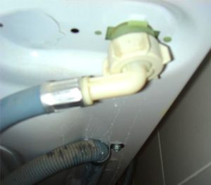 L'eau coule par le bas sous la machine à laver Atlant
