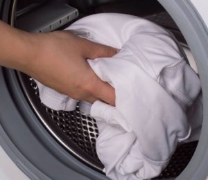 Naglalaba ng puting maong sa washing machine