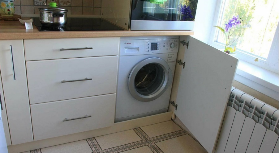 máquina de lavar roupa na cozinha perto da janela