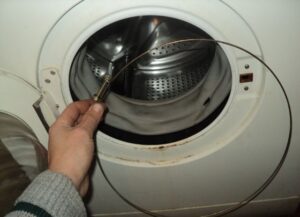 Hoe plaats je een veer op een wasmachinetrommel?