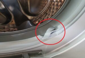 Manchetten i vaskemaskinen mellem tromlen og lågen er revet i stykker