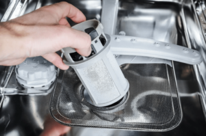 Should water remain in the dishwasher filter compartment?