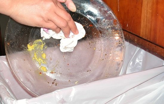 membersihkan pinggan mangkuk sebelum meletakkannya di PMM