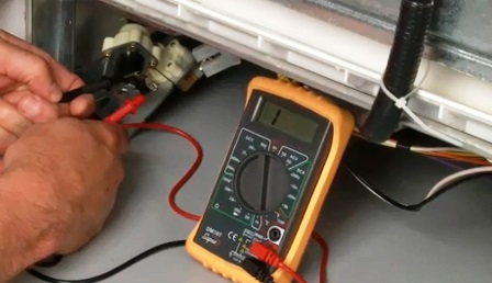 comprovant l'element de calefacció del rentavaixelles amb un multímetre
